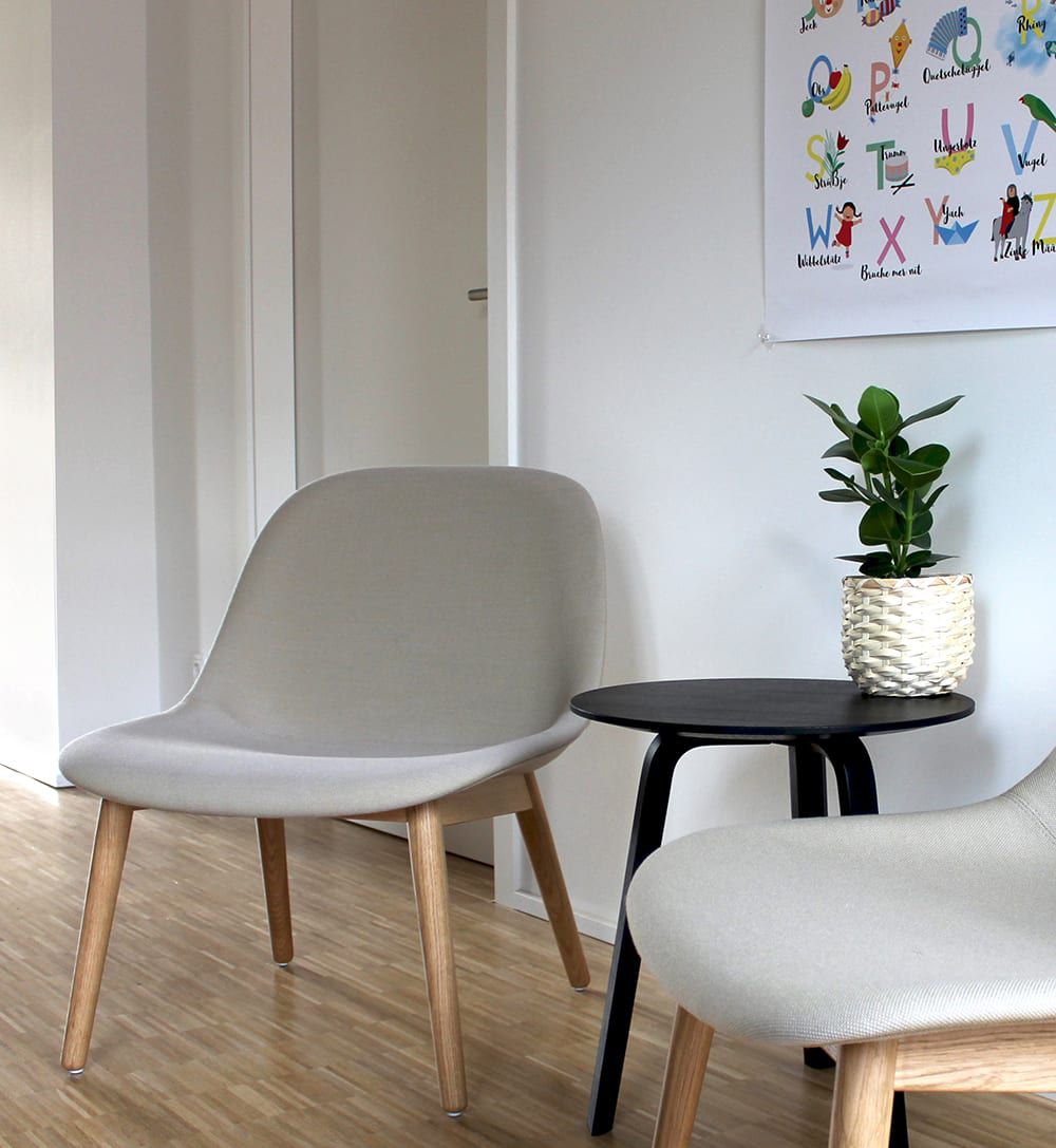 Ein Bild von zwei grauen Stühlen und einem schwarzen Tisch.